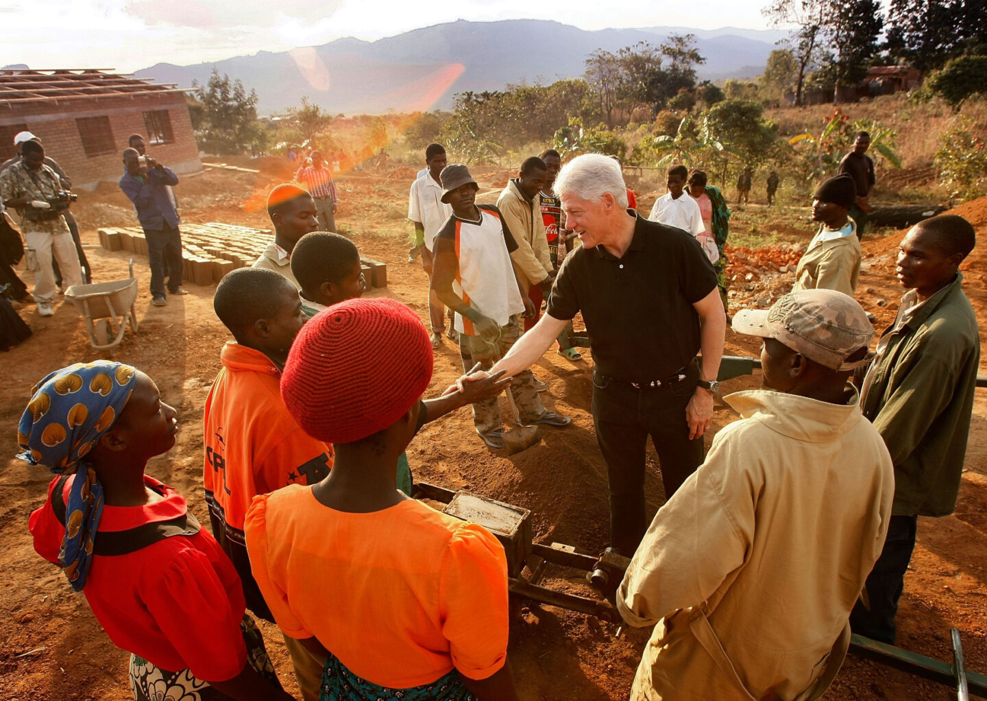 President Clinton shakes hands with locals and workers at a construction site in Africa