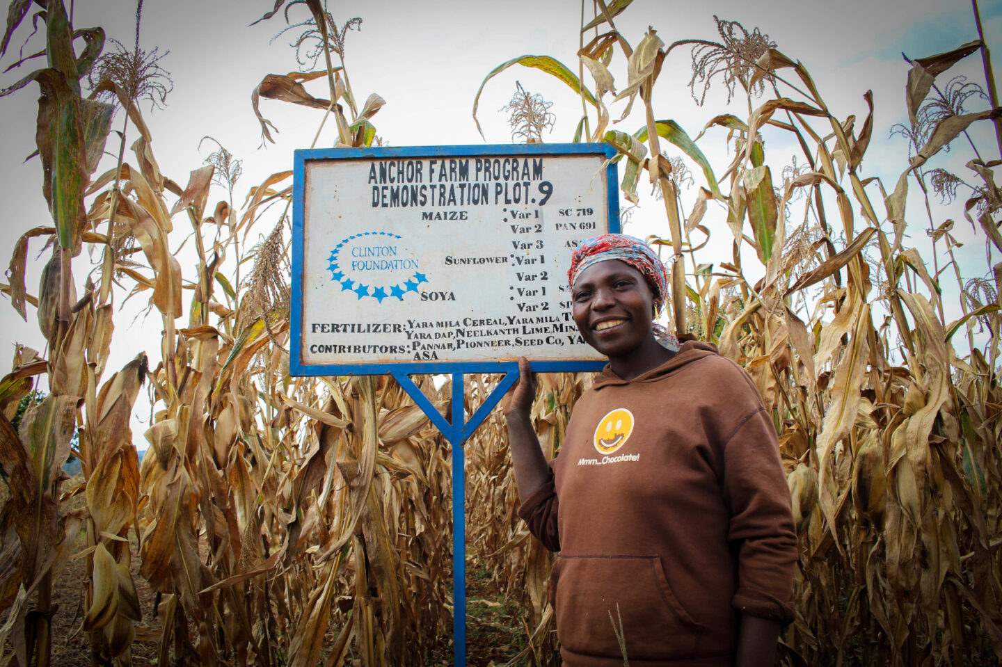 A farmer stands in front of some of her crops in Tanzania