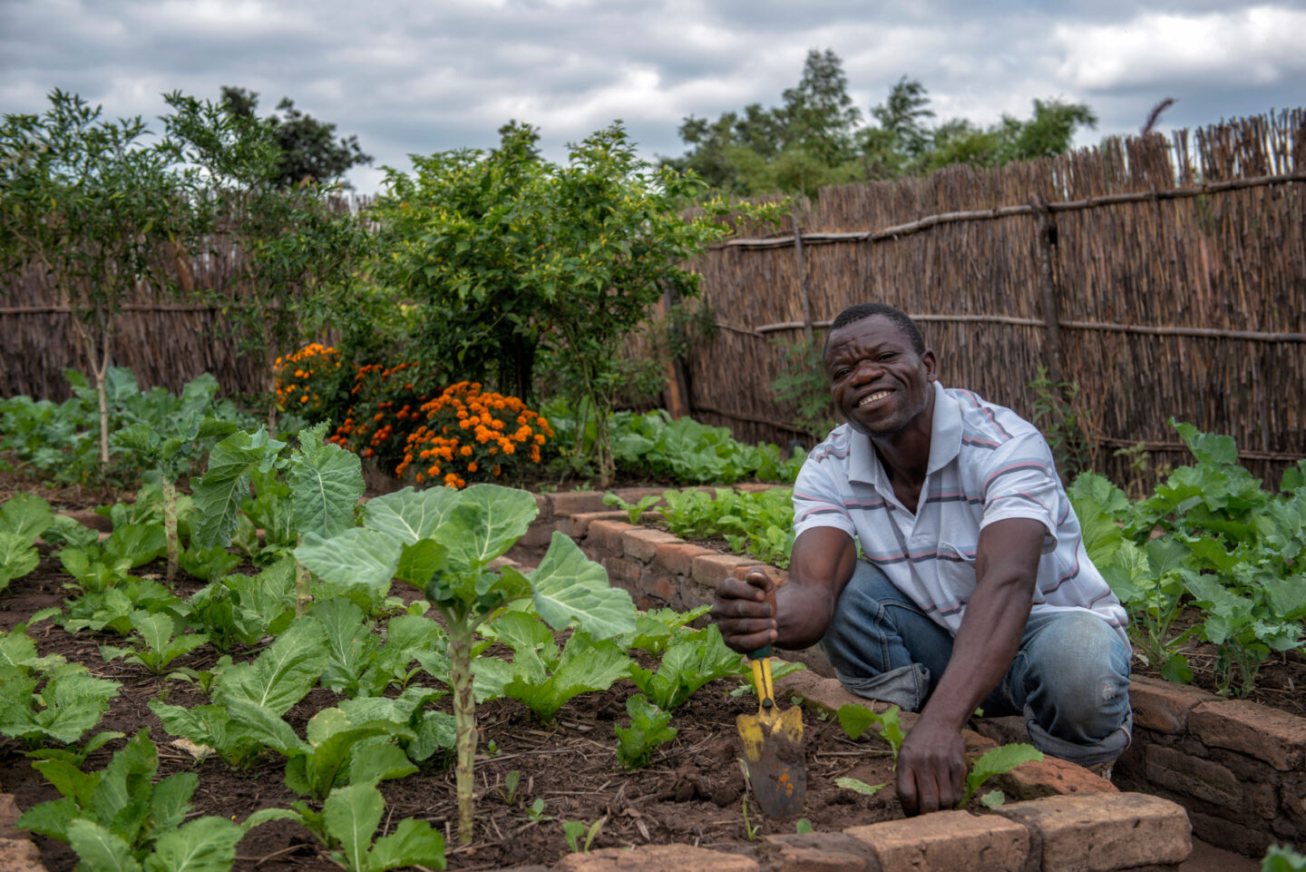 A farmer sits in their vegetable garden in Malawi