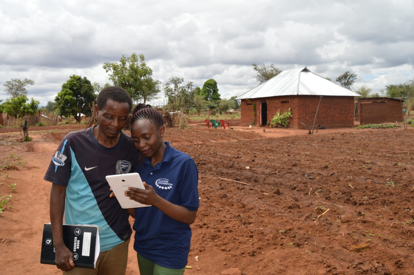 A Clinton Foundation staff member visits a farmer in Tanzania