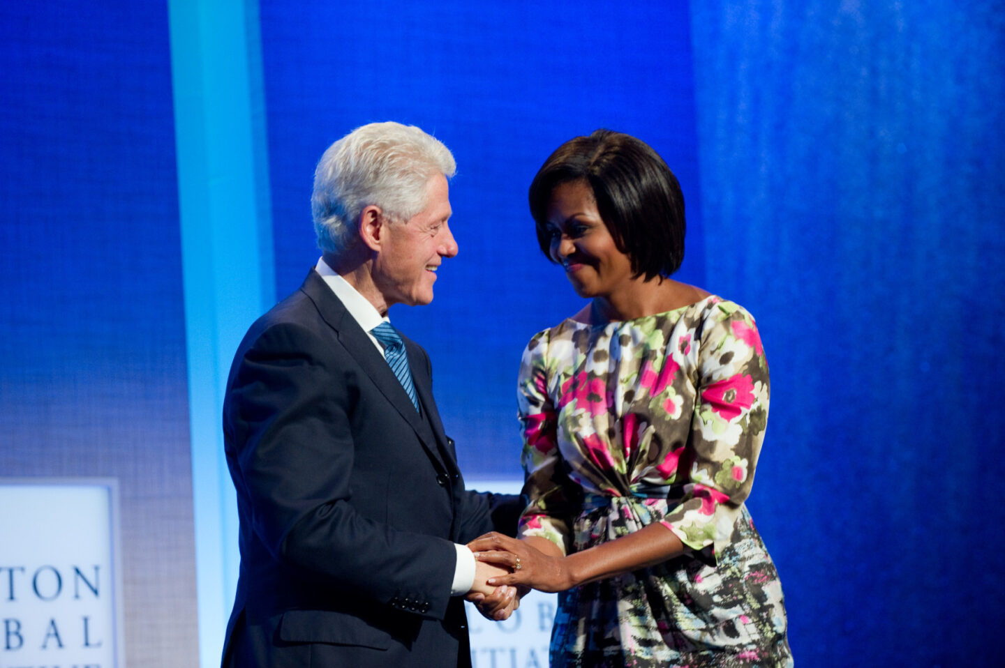 President Clinton and Michelle Obama shake hands on stage
