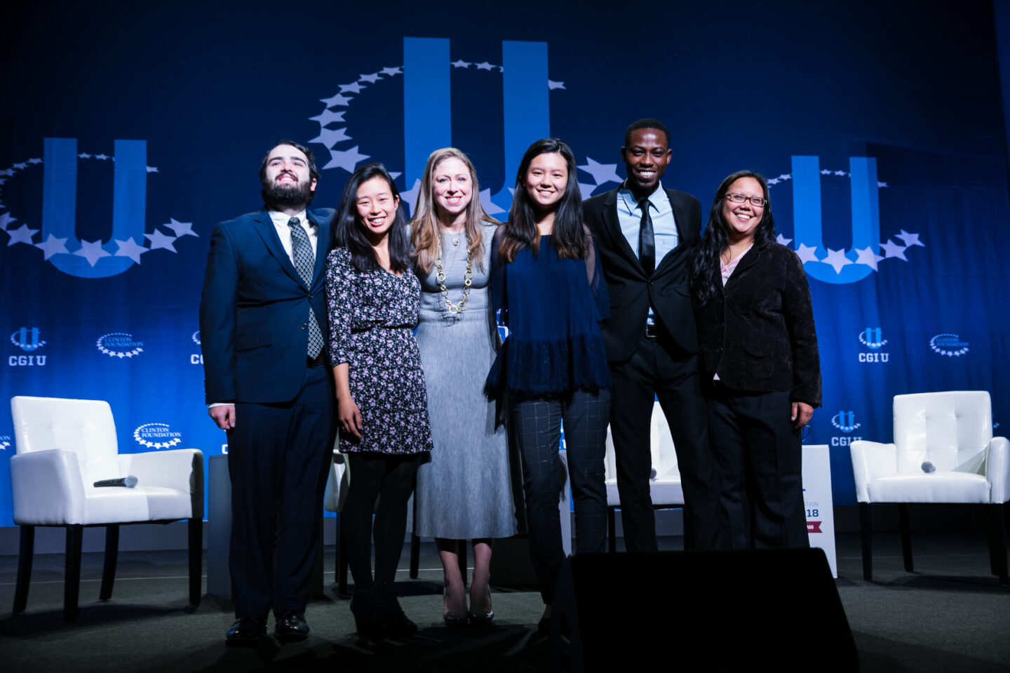 Chelsea Clinton stands onstage with group of CGI U students