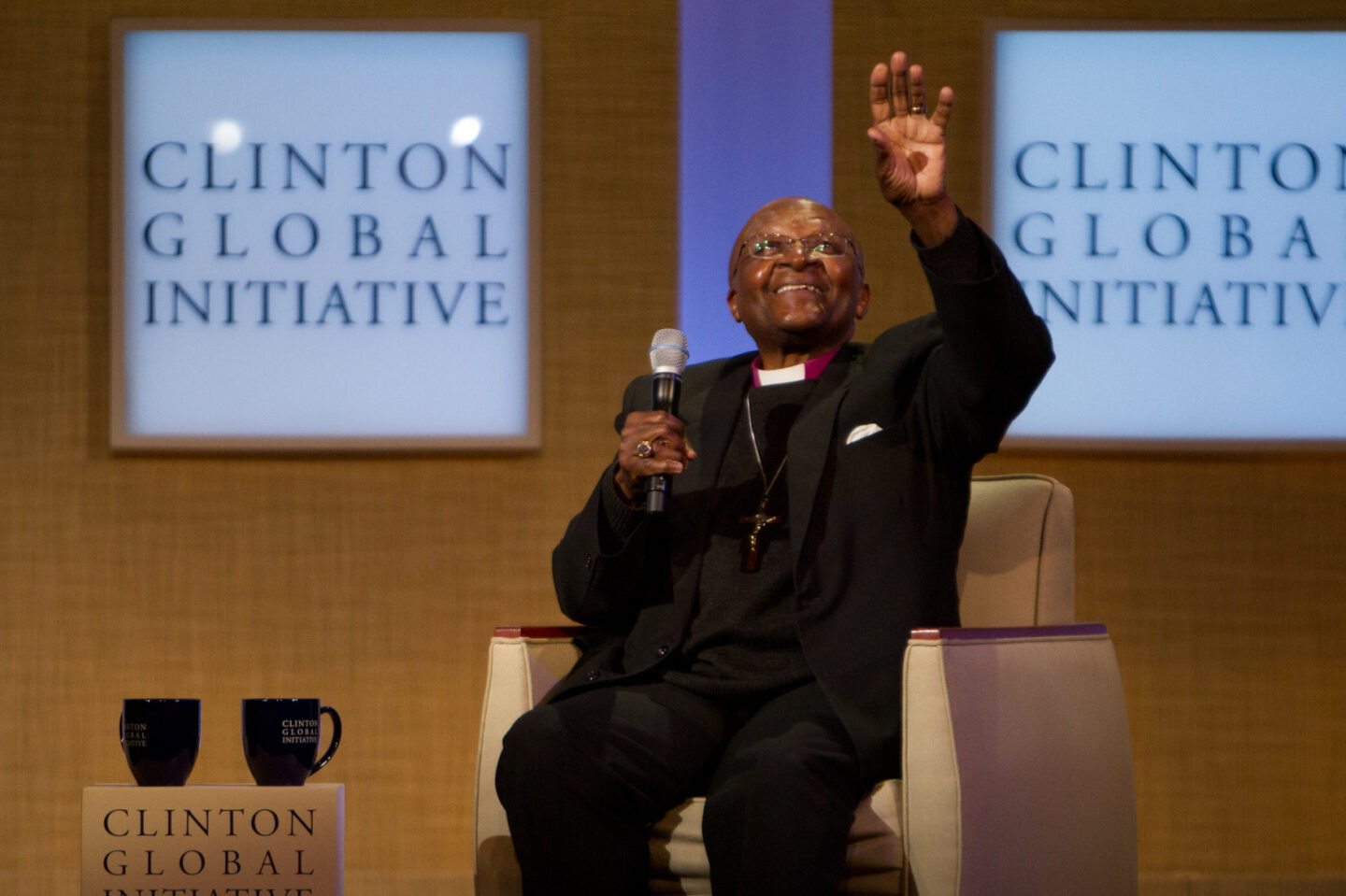 Desmond Tutu waves to the crowd during a plenary session