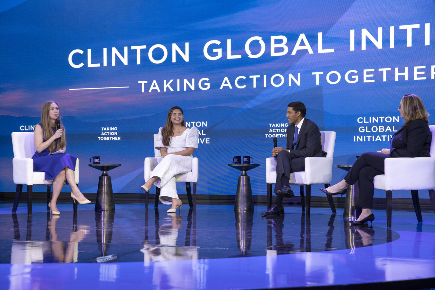 Chelsea Clinton, Marinel Sumook Ubaldo, Dr. Rajiv Shah, and Peggy Clark are seated onstage