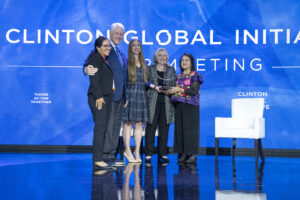 President Clinton, Secretary Clinton, and Chelsea Clinton present an award onstage to Dolores Huerta, who is joined by her daughter