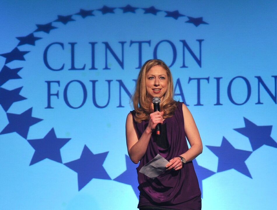 Chelsea Clinton speaks onstage in front of a Clinton Foundation logo