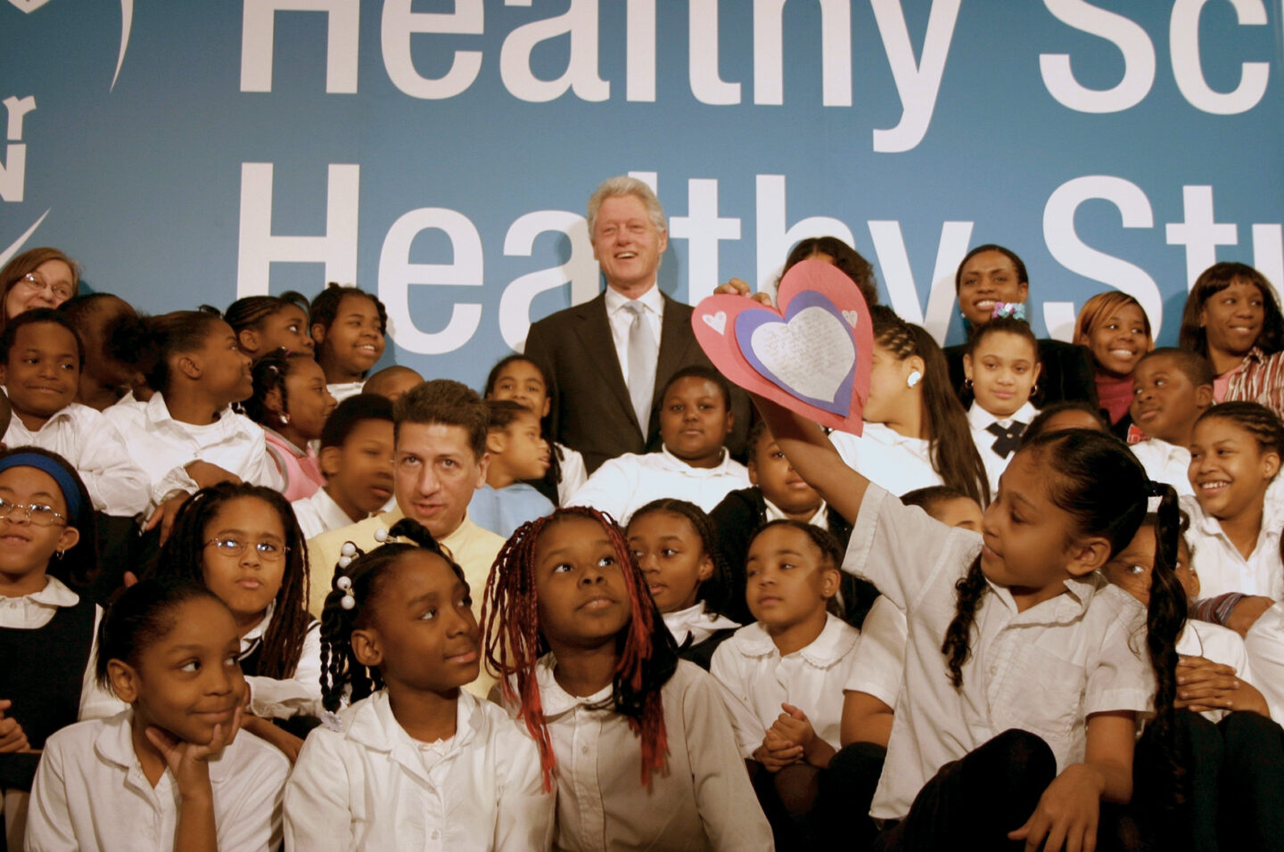 President Clinton takes a photo with a group of students