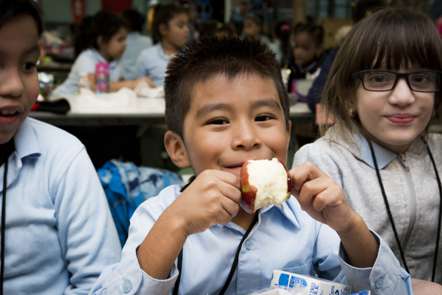 A student eats an apple during lunch