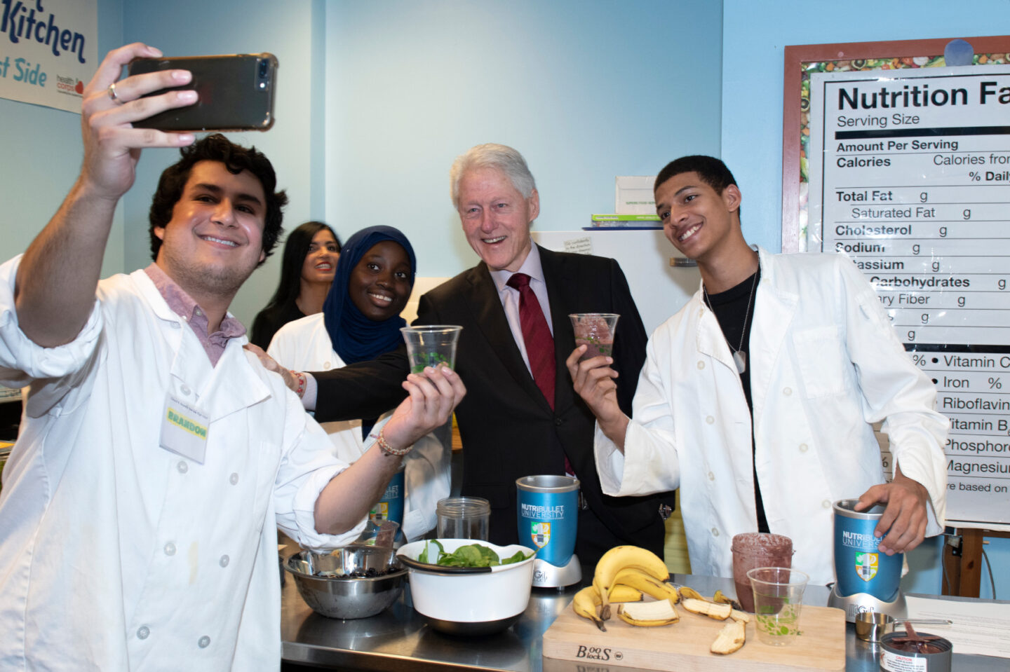 President Clinton helps students make a smoothie at a high school in New York City