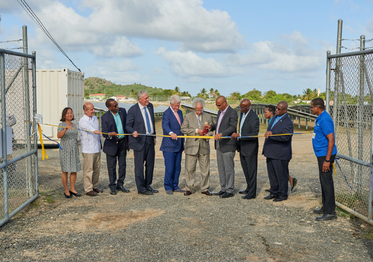 President Bill Clinton, government leaders, and others cut a ribbon to open a solar farm in St. Lucia