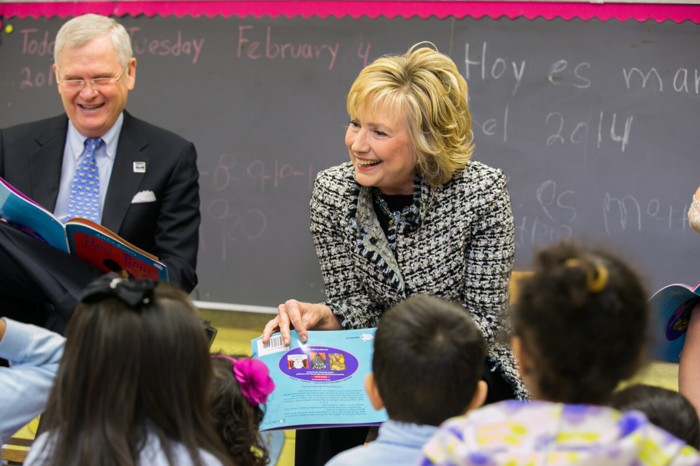 Secretary Hillary Clinton holds a book in front of a class of students