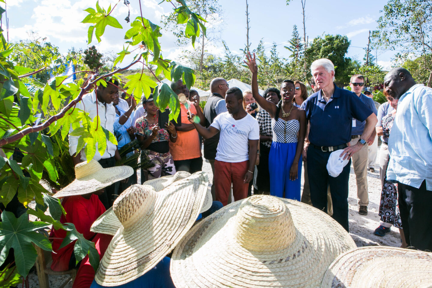 President Clinton and a group of individuals observe a tree