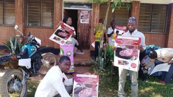 Individuals hold up posters about hand washing
