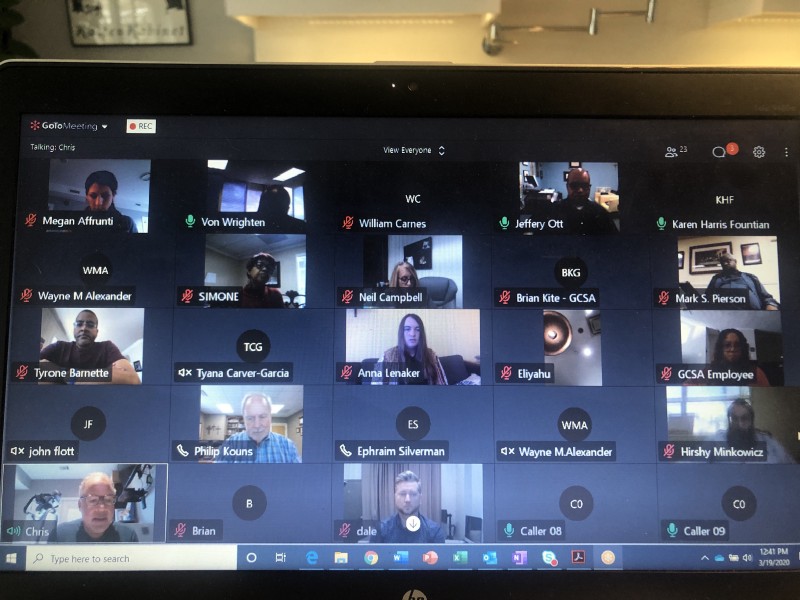 A photo of a laptop with a virtual meeting taking place on the screen