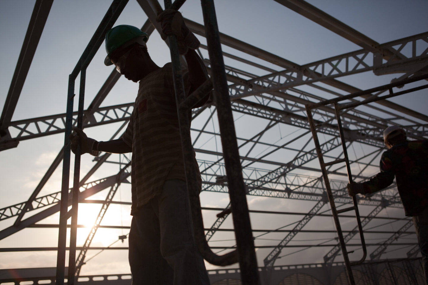An individual wearing a hard hat stands amid a construction project