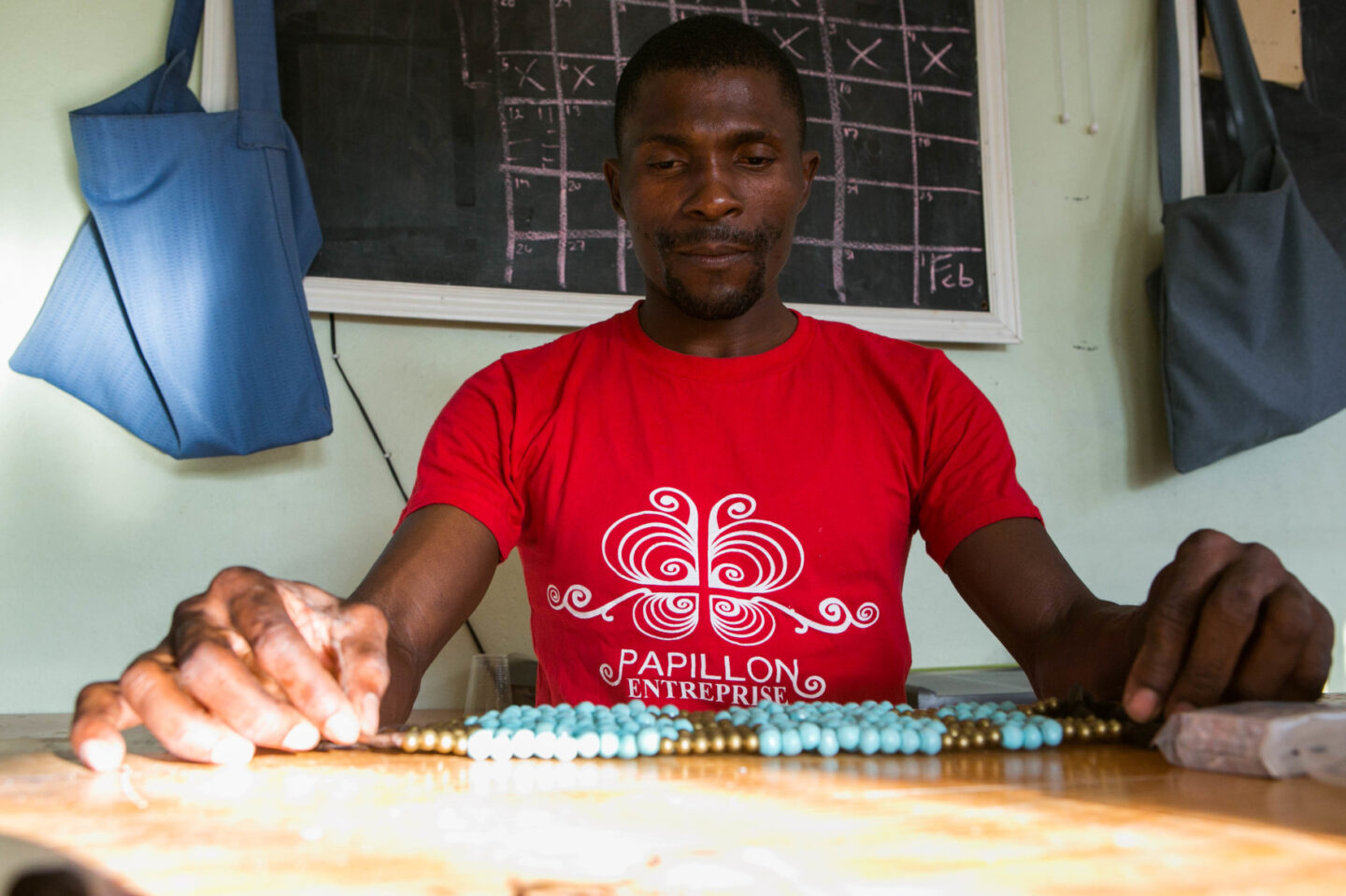 An individual puts together an artisanal piece using beads