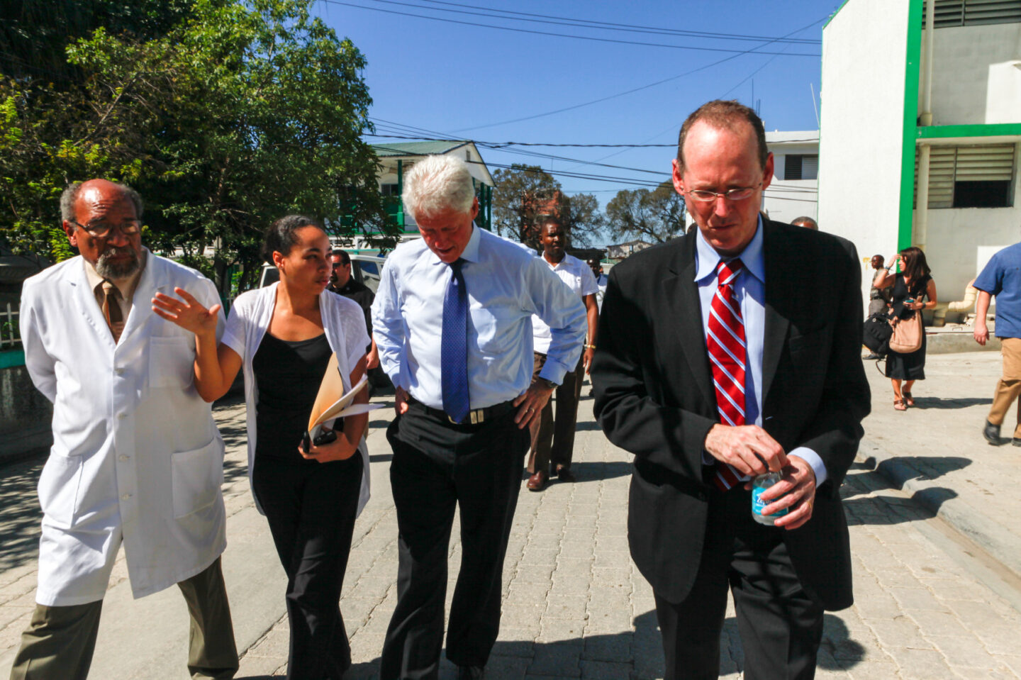 President Clinton walks with several individuals including medical professionals