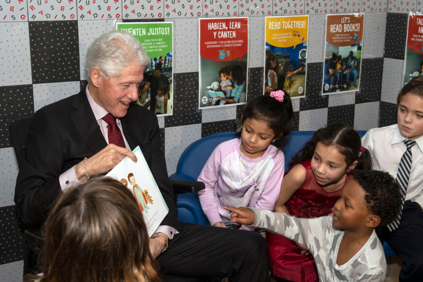 President Clinton reads a book to a group of children.