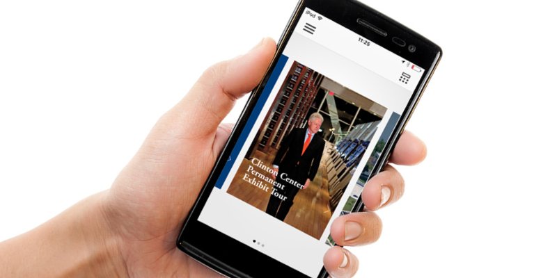 Close-up of hand holding phone with Clinton Presidential Center mobile app opened