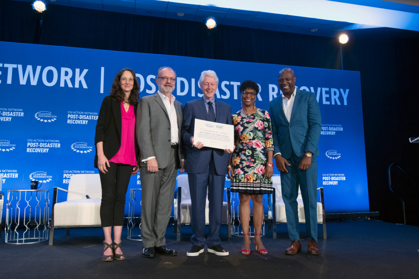 President Clinton takes a photo on stage with commitment-makers