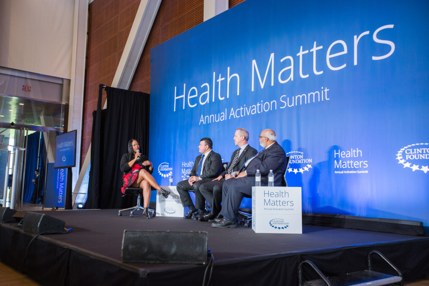 Individuals speak onstage at an event