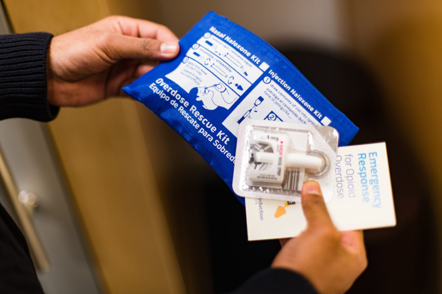 Close-up of hands holding a pouch with naloxone nasal spray