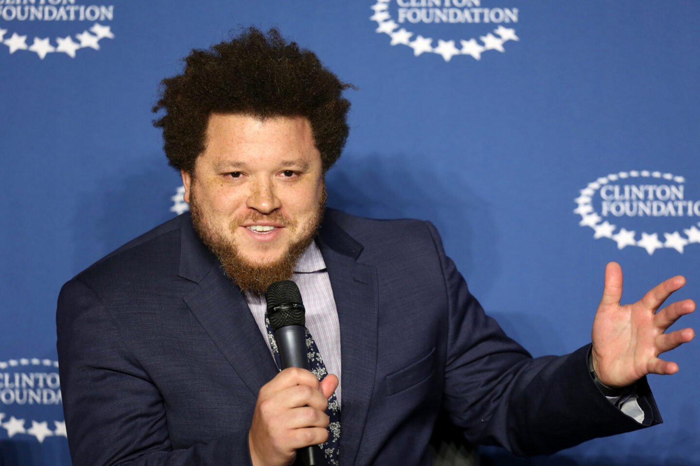 An individual speaks into a microphone onstage