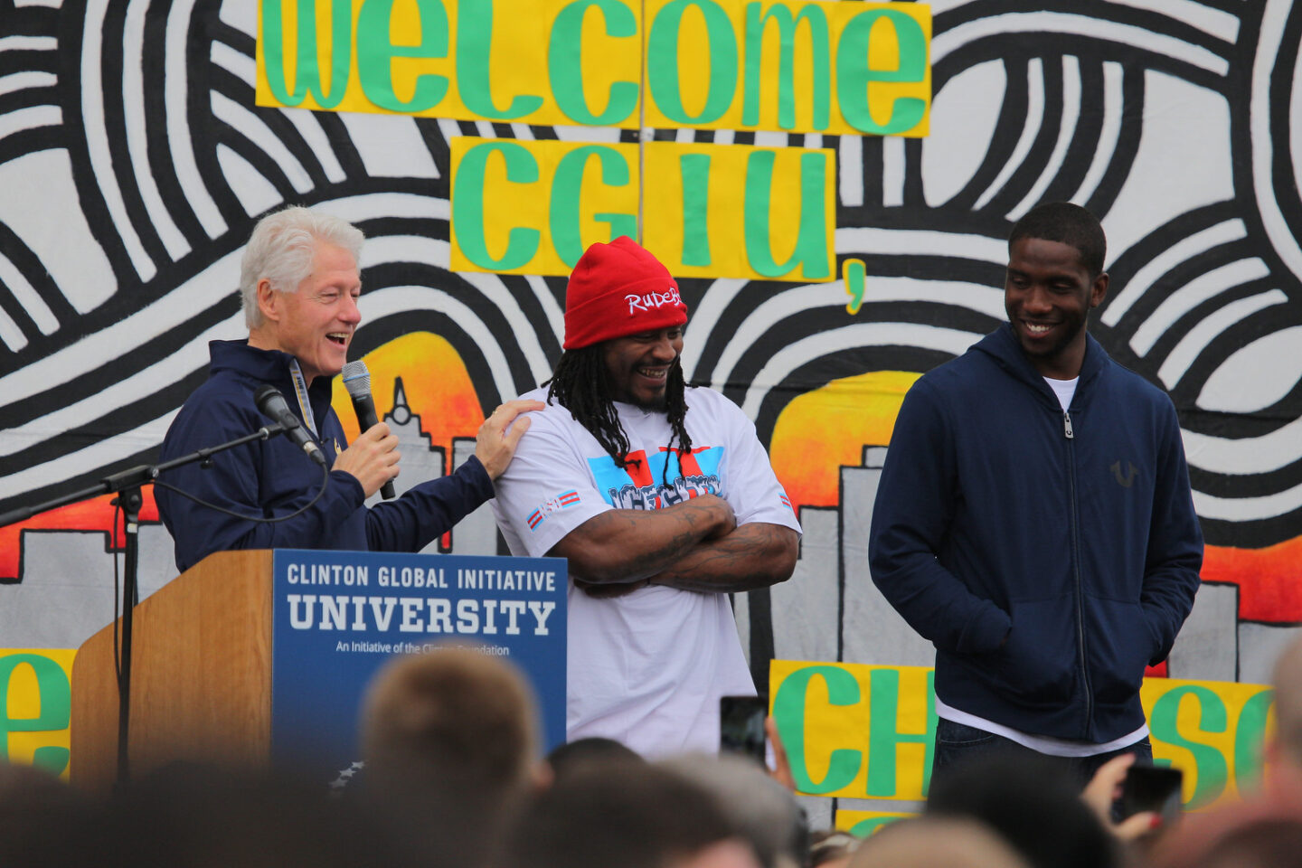 President Clinton and Marshawn Lynch stand onstage