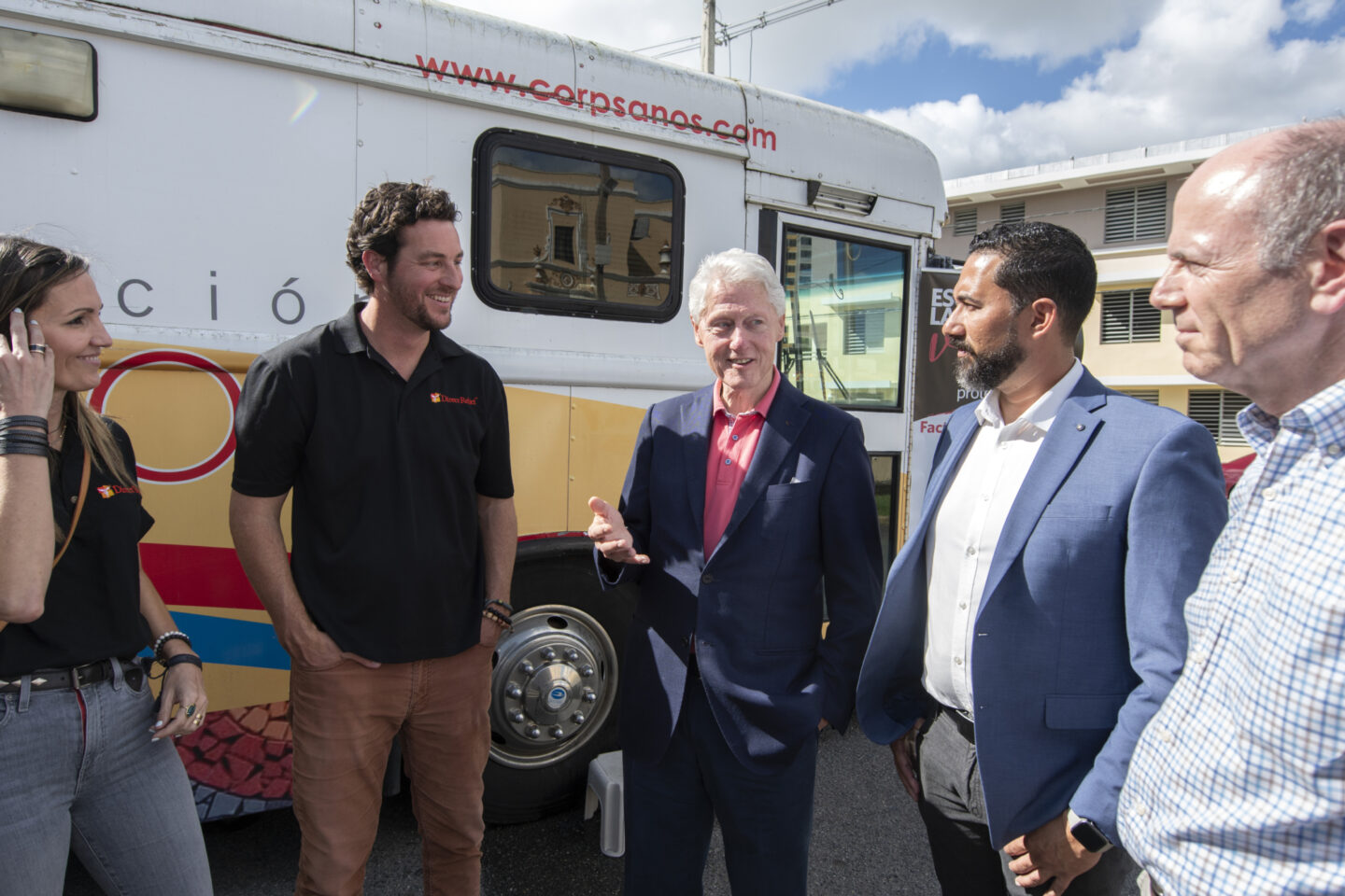 President Clinton speaks with individuals outside a mobile care unit