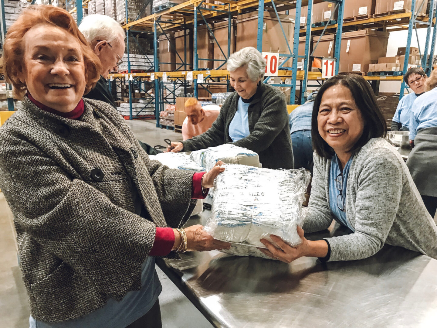 Volunteers hold a bundle of diapers