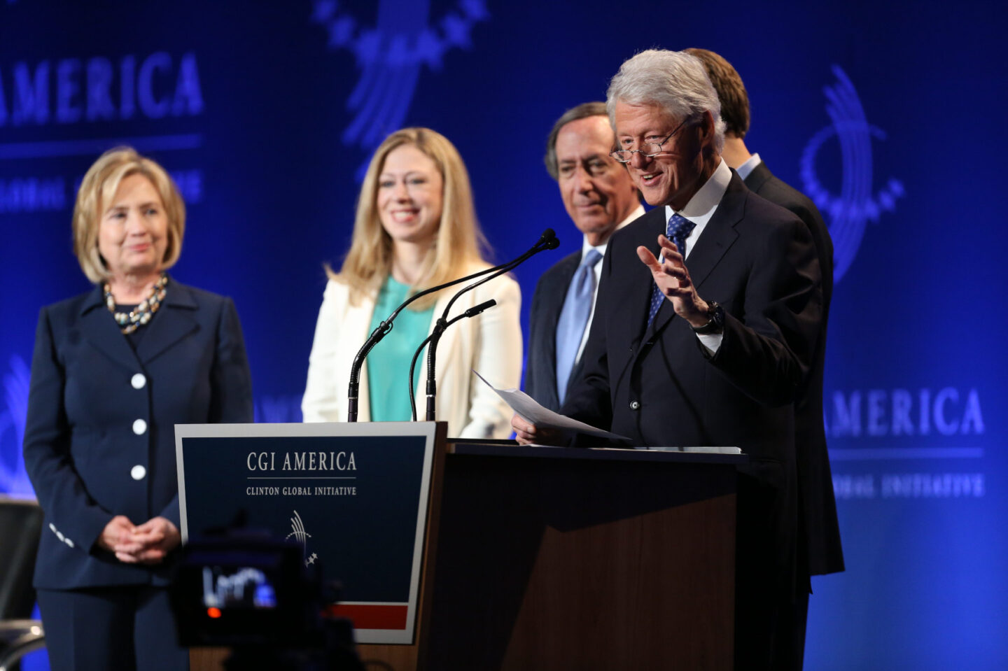 President Clinton, Secretary Clinton, and Chelsea Clinton stand on stage