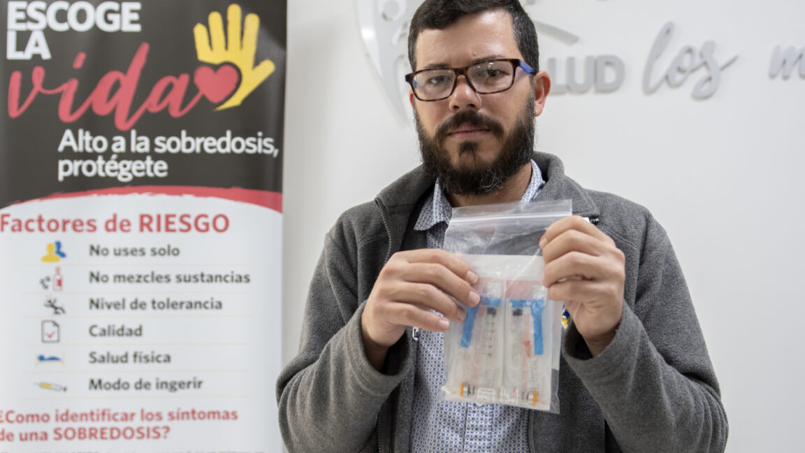 An individual holds a bag of medical supplies