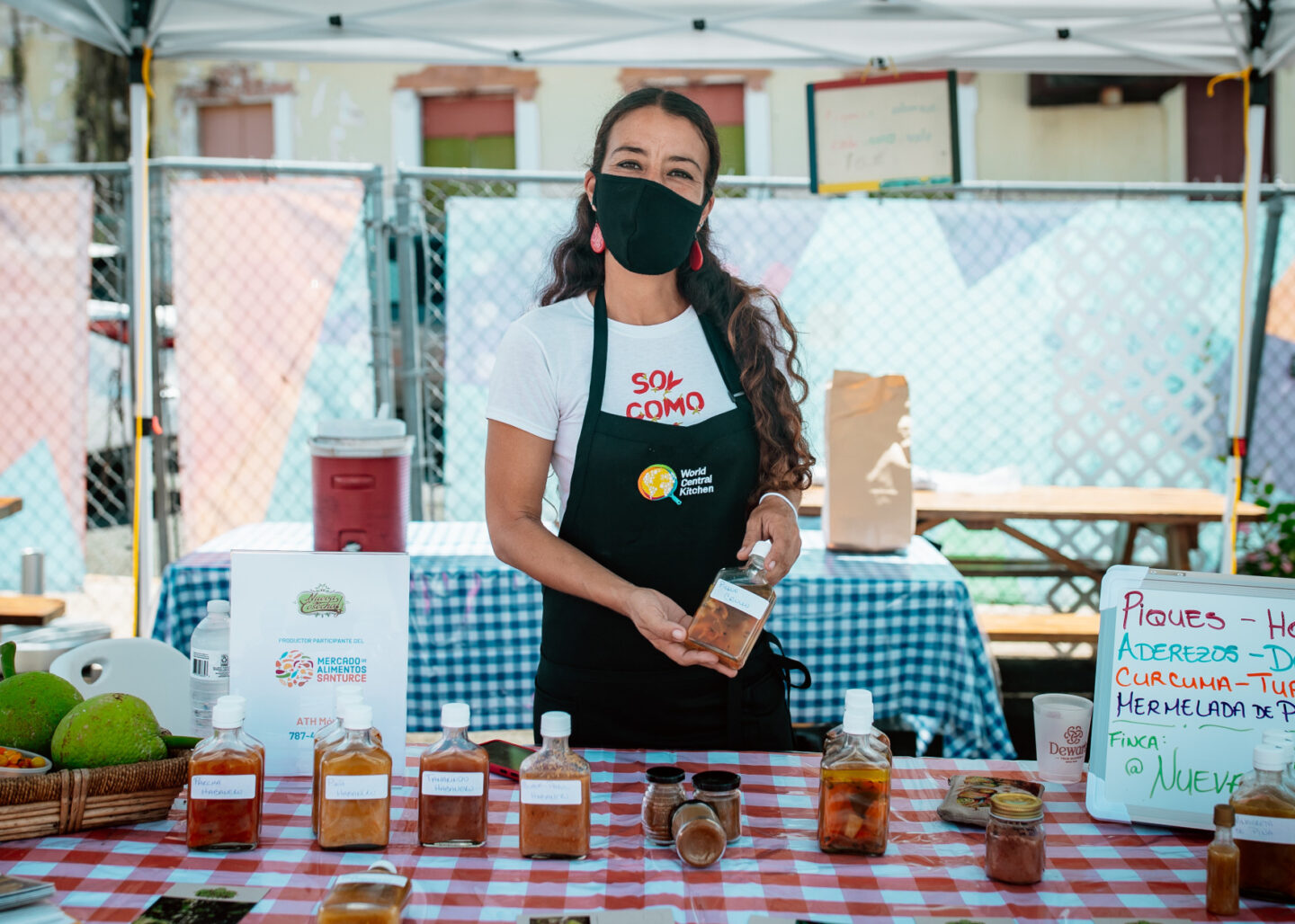 A representative from the World Central Kitchen stands at a table displaying various food items in Puerto Rico