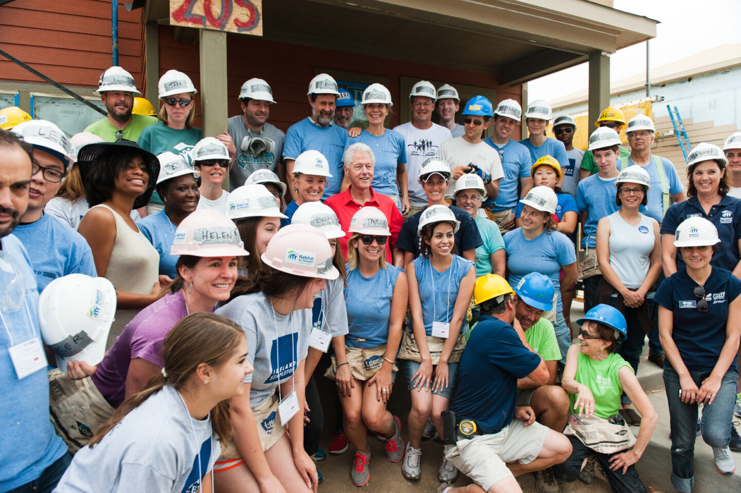 President Clinton with a large group of volunteers wearing hard hats