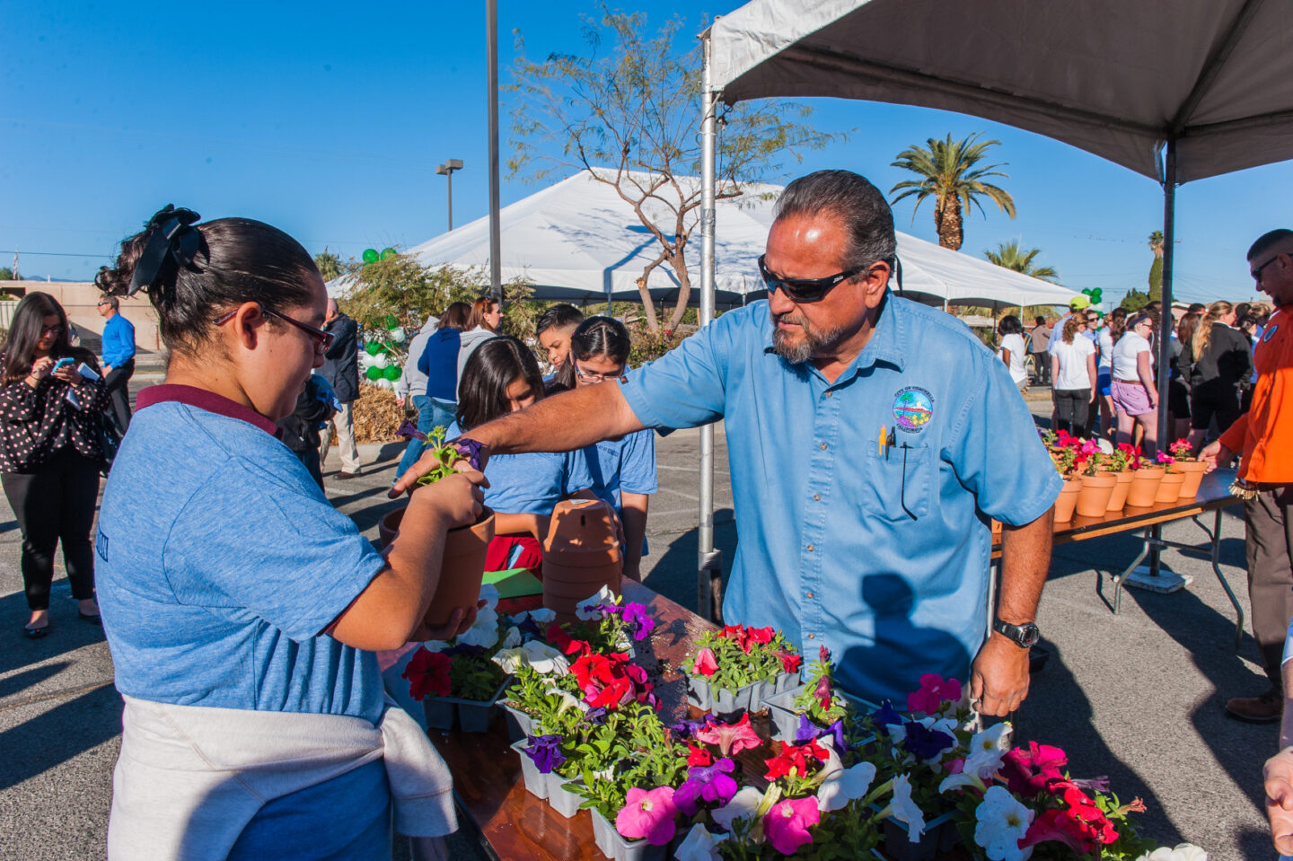 Volunteers hold containers with flowers