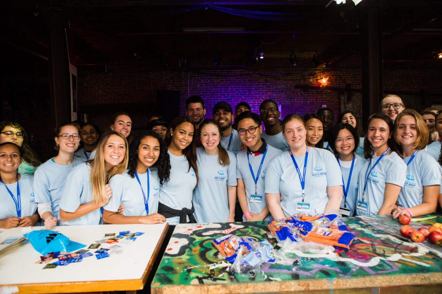 Chelsea Clinton stands with a large group of volunteers wearing "Day of Action" t-shirts