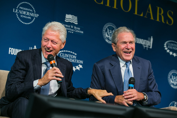 President George W. Bush and President Bill Clinton share a laugh on stage