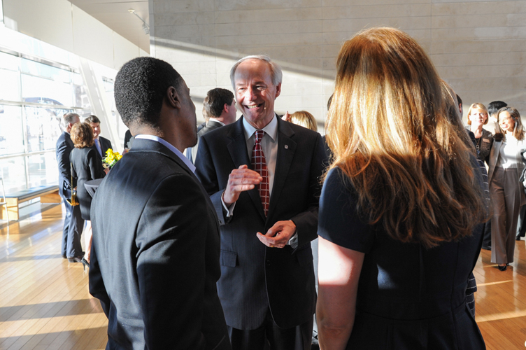 Governor Asa Hutchinson speaks with two individuals