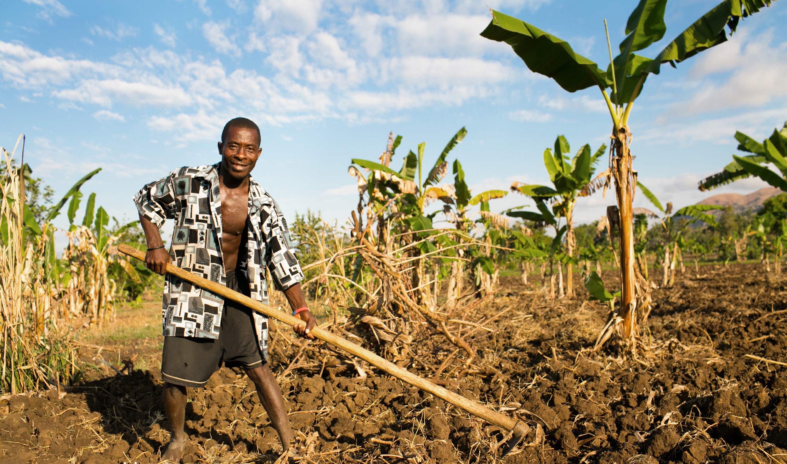 An individual holds a plow in the ground