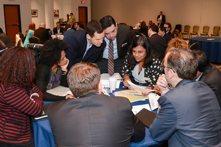 A group of individuals converse around a table