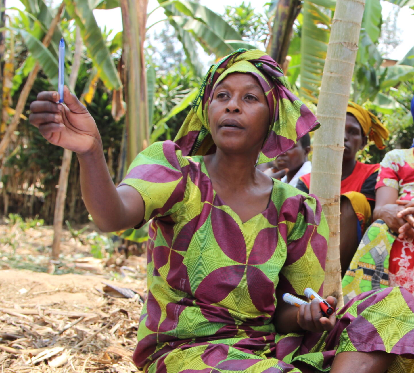 An individual holds up a pen while participating in a community mapping exercise