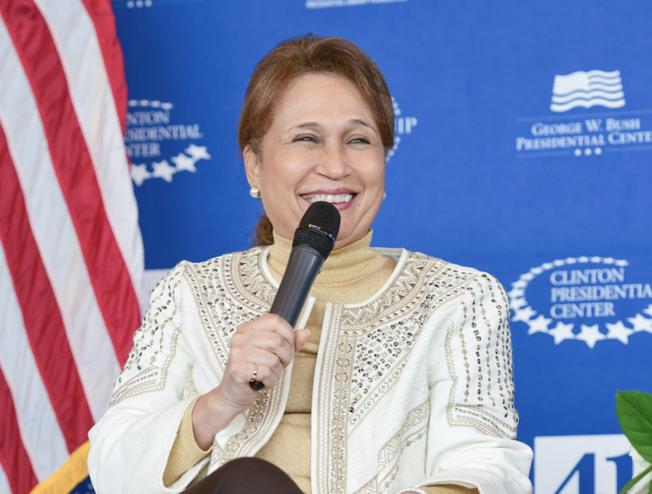 Alexis Herman holds a microphone while speaking onstage