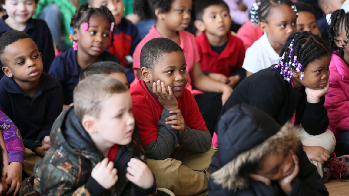 Close-up of group of elementary students seated during event