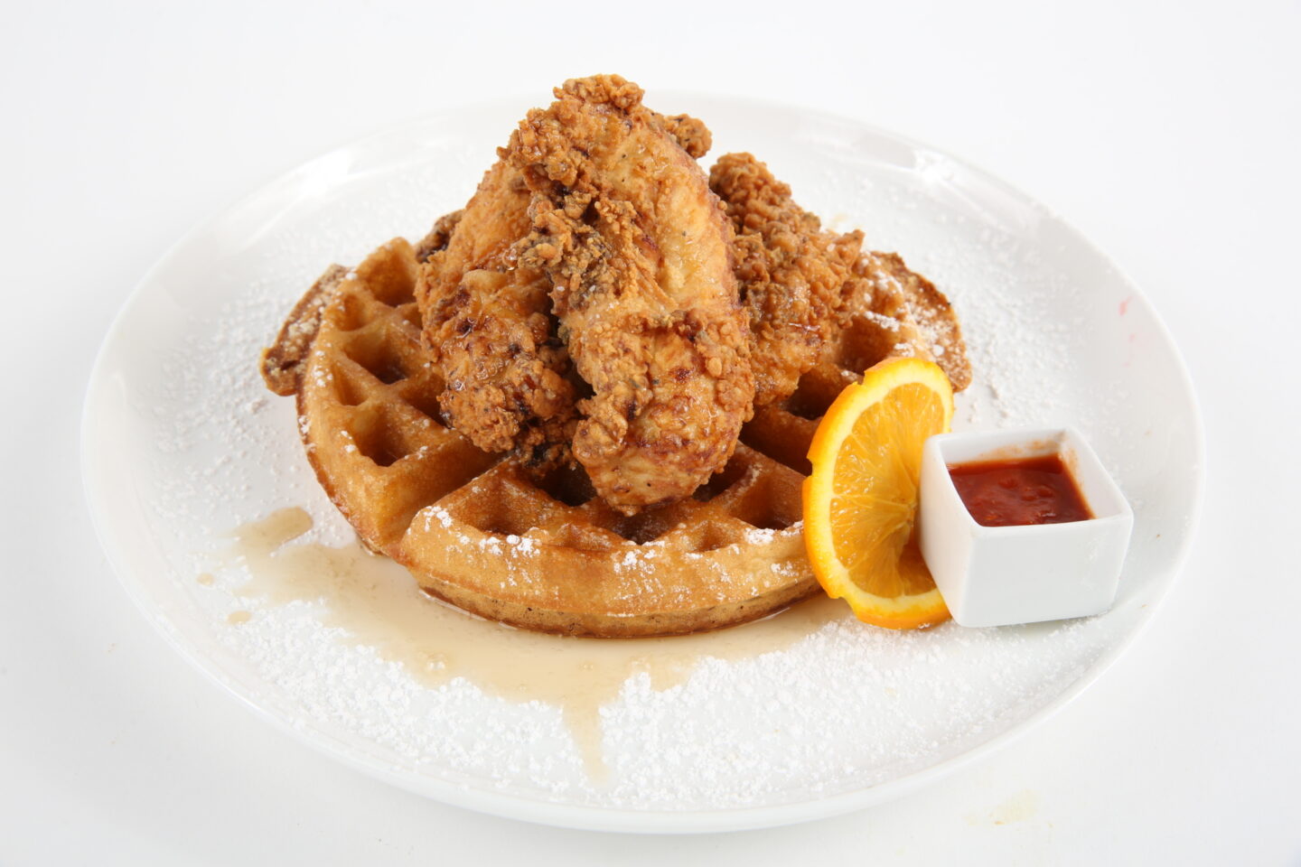 Plated meal which includes chicken and waffles