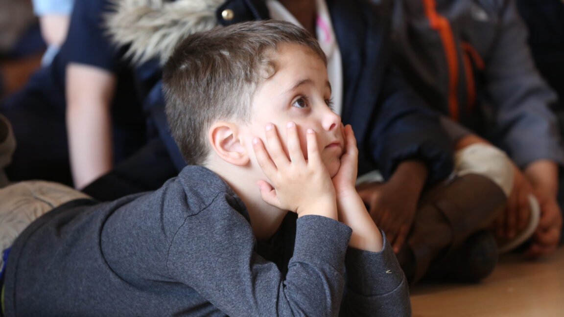 An elementary student listens to a book during the Clinton Center's Read Across America Celebration in 2020.