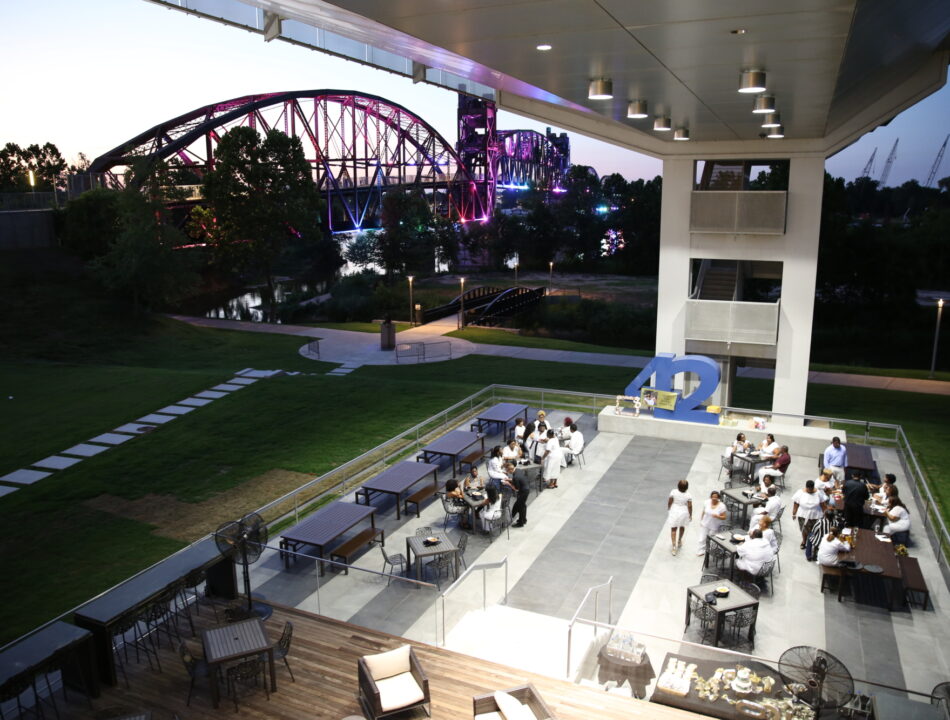 Wide shot of guests dining on 42 bar and table terrace with Clinton Presidential Park Bridge in background