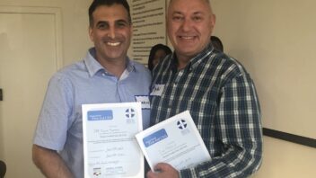 Two individuals hold certificates that read "Mental Health First Aid USA"