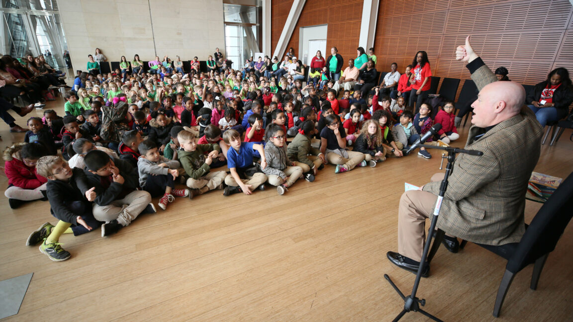 Little Rock School District Superintendent Michael Poore reads a book to students during Read Across America Week at the Clinton Center.