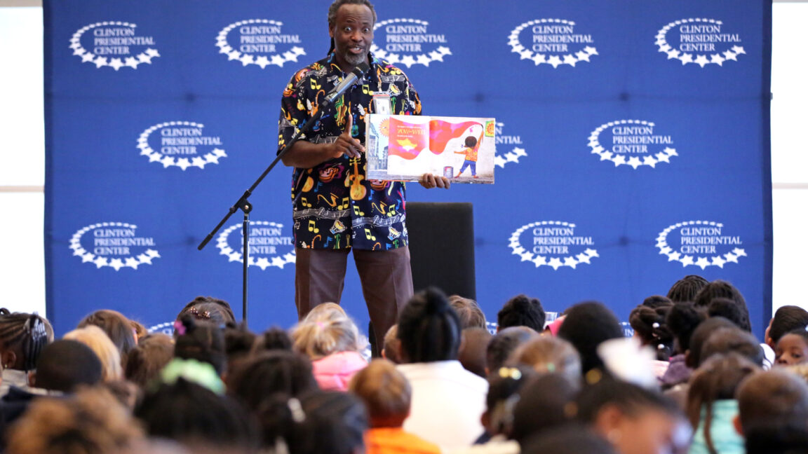 An educator reads to elementary students at the Clinton Center in Little Rock, Arkansas