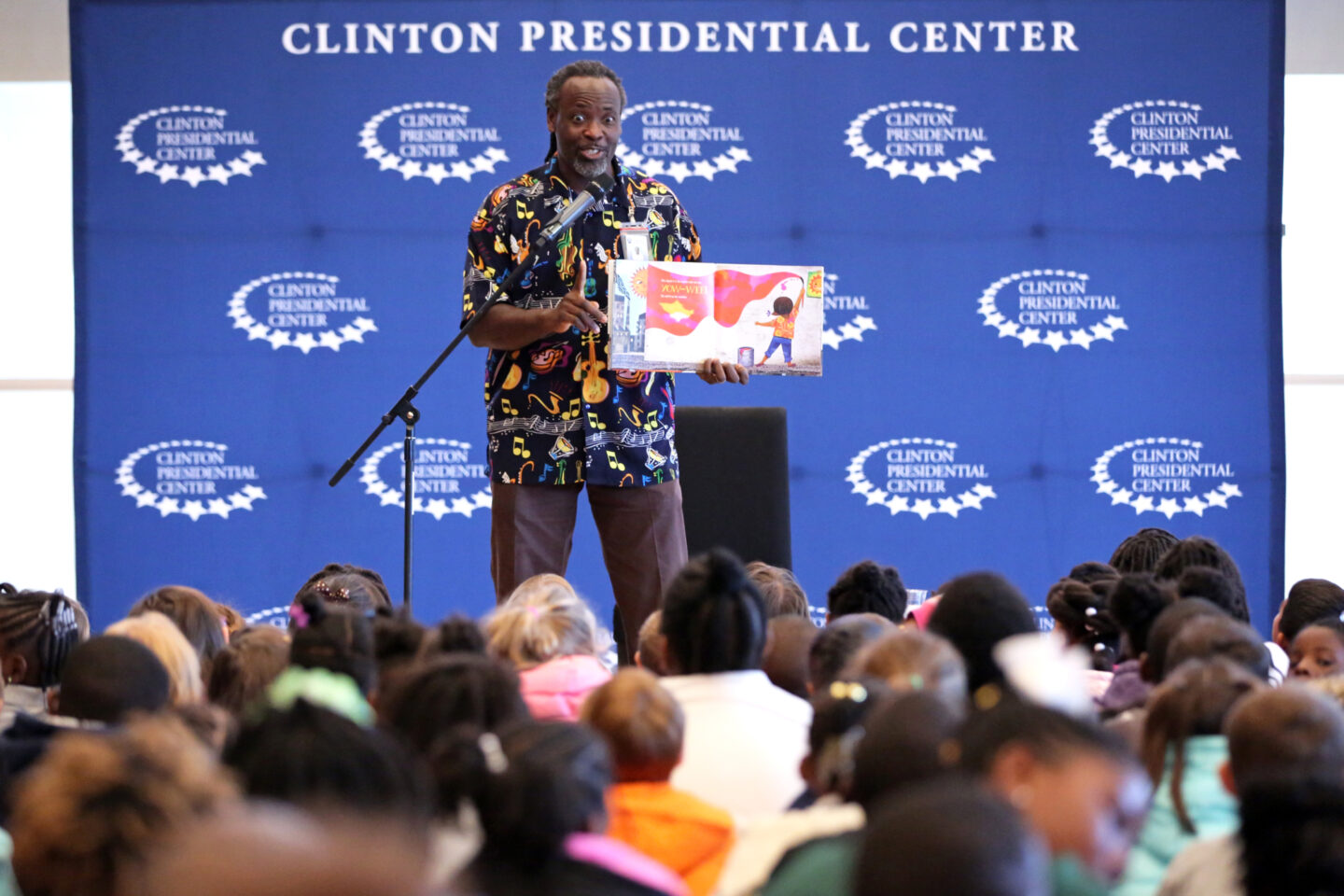 An educator reads to elementary students at the Clinton Center in Little Rock, Arkansas